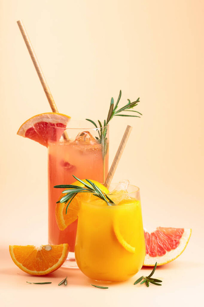 Orange and grapefruit juice in glasses with rosemary and ice. Copy space. - Foto, Bild