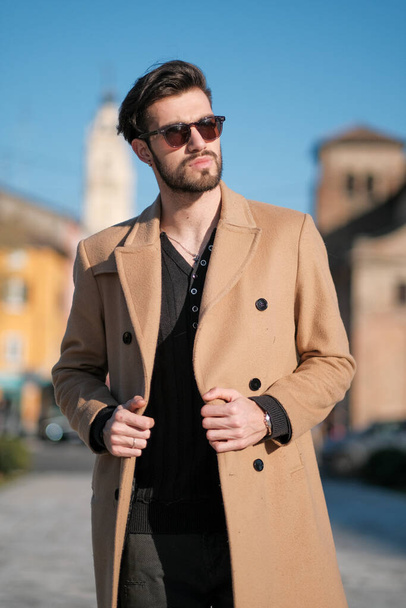 handsome Italian boy walks with coat in the historic center of Parma. High quality photo - Fotó, kép