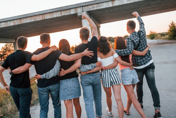 View from behind. Group of young cheerful friends having fun together. Party outdoors. - Foto, afbeelding