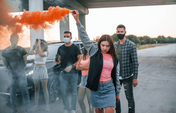 Using smoke. Group of protesting young people that standing together. Activist for human rights or against government. - Foto, Imagem