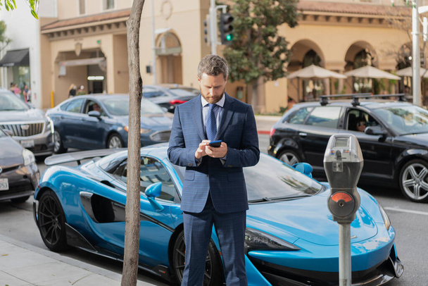 hombre de negocios alquilar un coche de lujo por teléfono. alquiler online - Foto, imagen