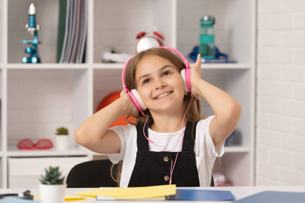 весела дитина слухати музику в навушниках у шкільному класі
 - Фото, зображення