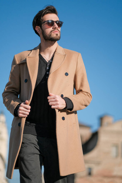 Красивый итальянский мальчик ходит в пальто в историческом центре Пармы. Высокое качество фото - Фото, изображение