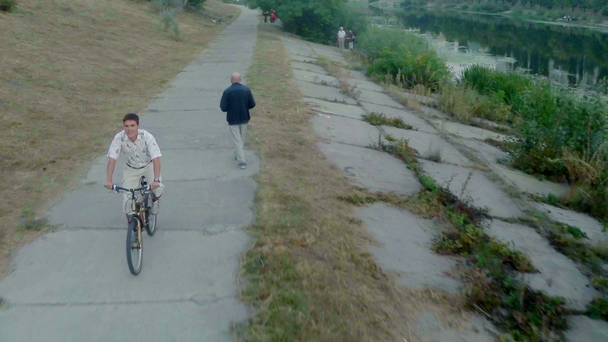 hombre montar en bicicleta en el parque de la ciudad - Imágenes, Vídeo