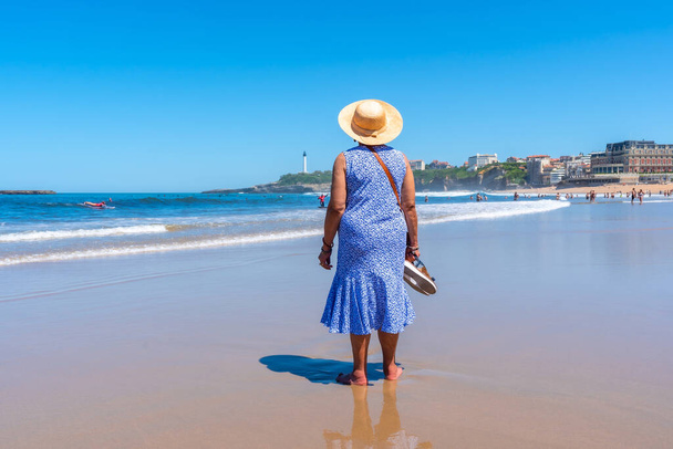An elderly woman walking on the beach in Biarritz, Lapurdi. France, South West resort town - Photo, image