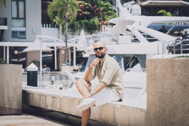 Portrait of a fashion young man posing at marina and yahts background - Valokuva, kuva
