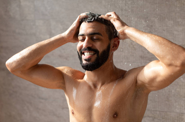 przystojny uśmiech młody arabski mężczyzna model biorąc gorący prysznic - Zdjęcie, obraz