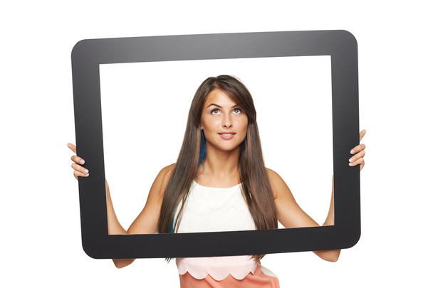 Woman looking to side through tablet frame - Fotó, kép