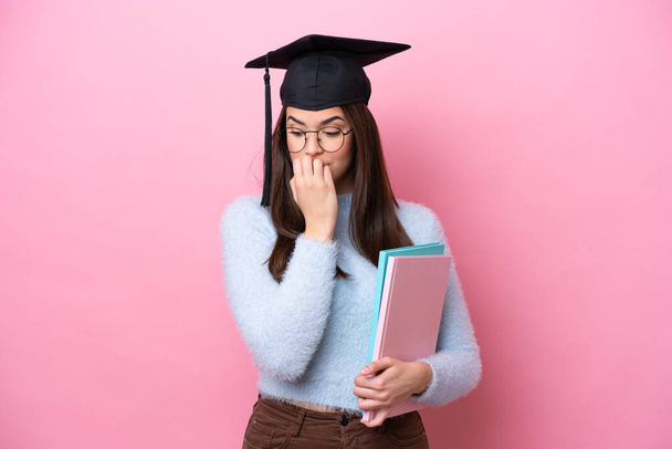 Young student Brazilian woman wearing graduated hat isolated on pink background having doubts - Photo, Image