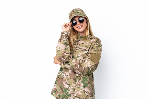 Mujer militar aislada sobre fondo blanco con gafas y feliz - Foto, Imagen