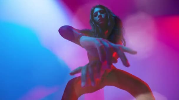 Žena tanečnice pózující na barevném pozadí - Záběry, video