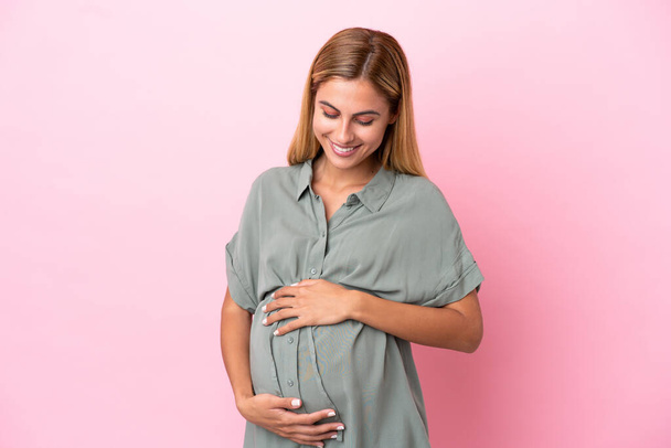 Νεαρή Ουρουγουανή γυναίκα απομονωμένη σε μπλε φόντο έγκυος - Φωτογραφία, εικόνα