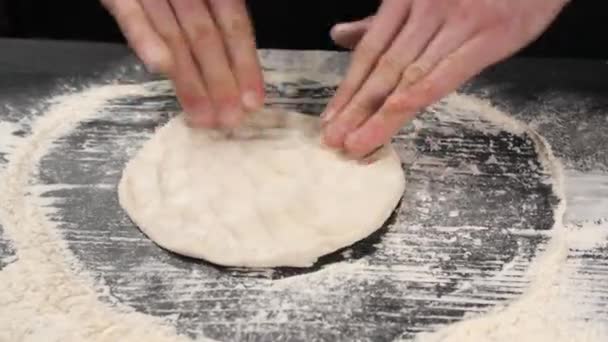 Le mani maschili dello chef fanno un vuoto per la pizza italiana dall'impasto. - Filmati, video