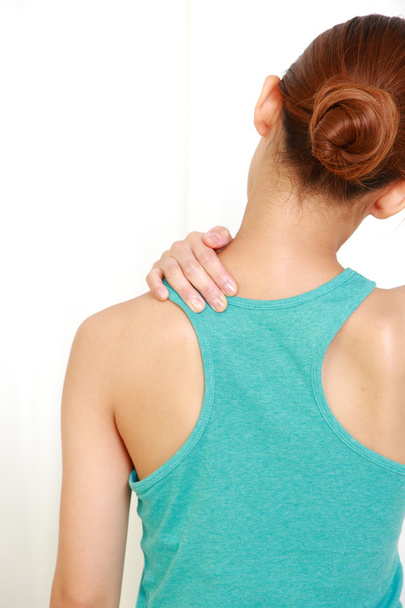 Young woman doing self shoulder massage - 写真・画像