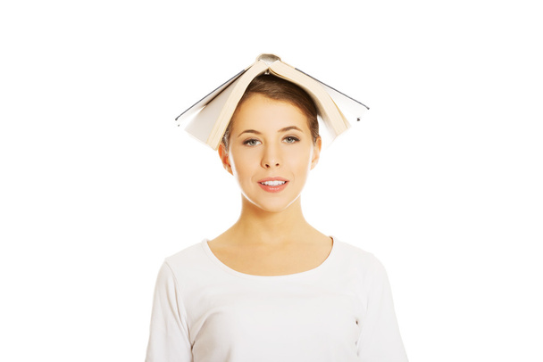 Woman holding book on head - Valokuva, kuva