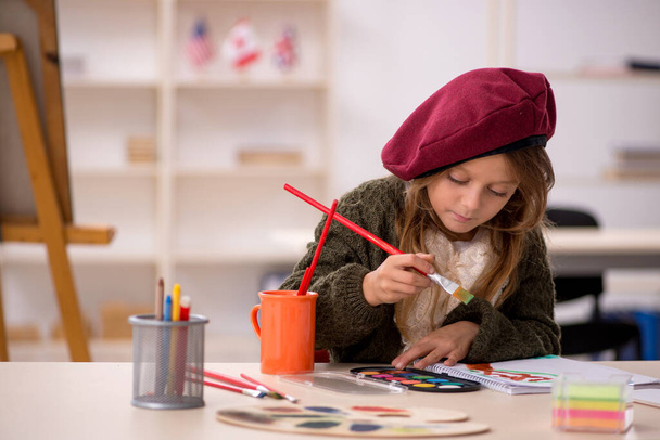 Νεαρό κοριτσάκι απολαμβάνει ζωγραφική στο σπίτι - Φωτογραφία, εικόνα