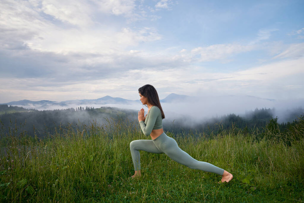 Active woman in sport clothes enjoying outdoors yoga - Foto, Imagen