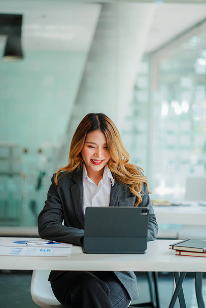 Portrait of smiling Asian businesswoman working in modern desk using tablet, freelance staff, online finance marketing concept, e-commerce by phone. - Foto, Imagem