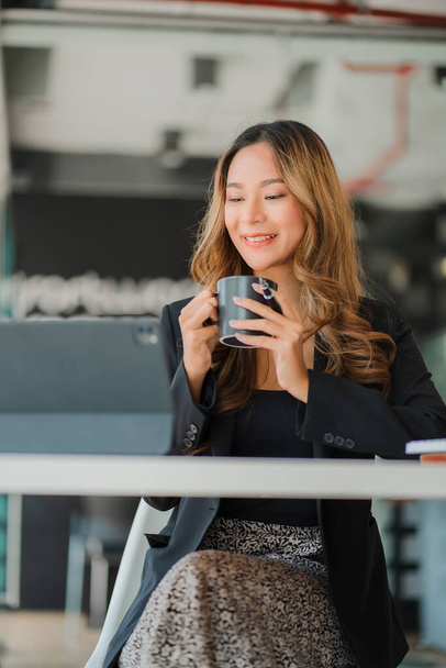 Portrait of smiling Asian businesswoman working in modern desk using tablet, freelance staff, online finance marketing concept, e-commerce by phone. - Foto, Bild