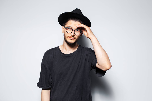 Studio portrait of young handsome man in black hat and glasses. - Photo, Image