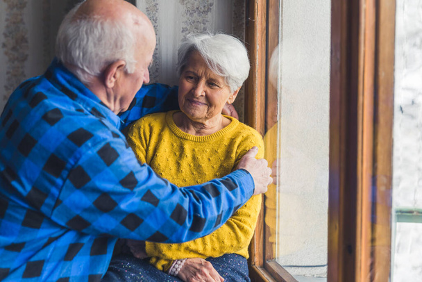 coppia anziana che si abbraccia davanti alla finestra medio colpo indoor senior people support concept - Foto, immagini