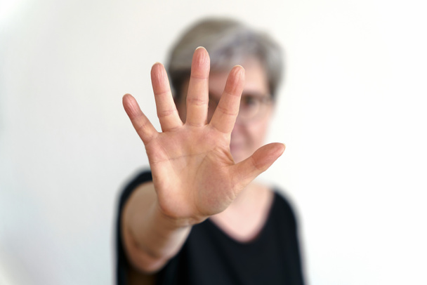     Eine erwachsene Frau schützt sich mit defensiven Handbewegungen                            - Foto, Bild