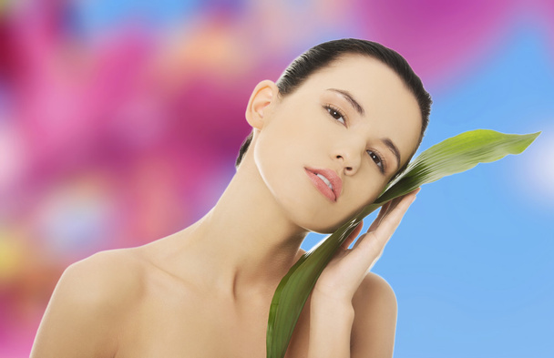 Женщина с художественным макияжем и бамбуковым листом
 - Фото, изображение