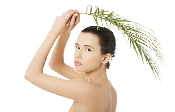 Femme nue tenant une feuille de palmier
 - Photo, image