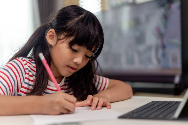Étude de classe d'apprentissage d'enfant asiatique mignon en ligne avec appel vidéo à partir de la tablette à la maison. - Photo, image