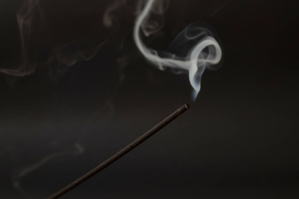 Bâton d'encens avec fumée sur fond noir. - Photo, image