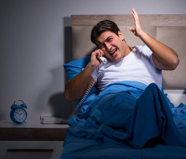 Jongeman worstelt met lawaai in bed - Foto, afbeelding