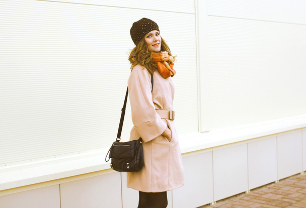Pretty woman in coat and hat walks in the city - Photo, Image