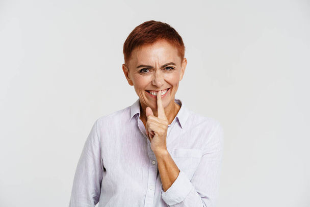 Ginger senior woman with short hair showing silence gesture isolated over white background - Φωτογραφία, εικόνα