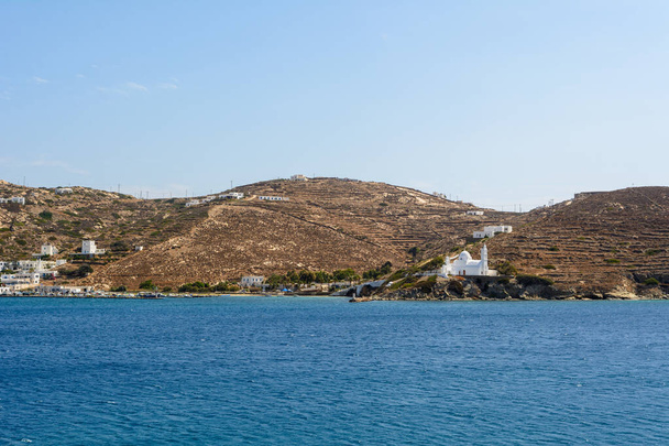 Il porto dell'isola di Ios in Grecia, una pittoresca baia con un piccolo insediamento e una caratteristica chiesa sulla collina. Isole Cicladi, Grecia - Foto, immagini