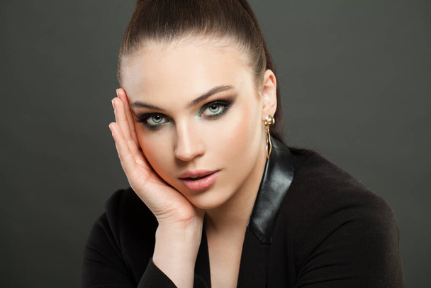 Elegant female model face with dark green smokey eyes makeup. Woman on black background - Foto, Imagen