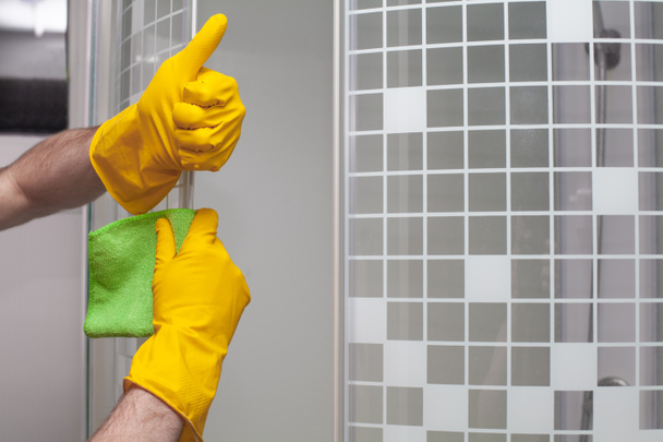 Man cleaning glass door in bathroom and showing thumb up closeup - Foto, Imagem