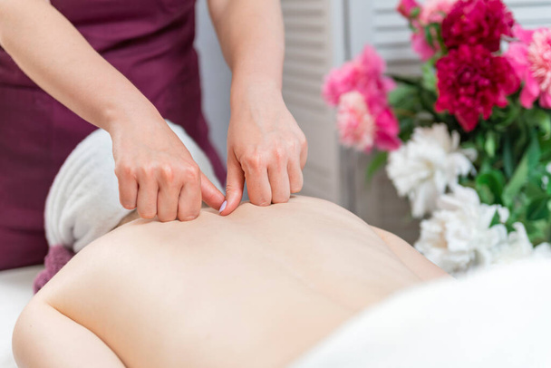 As mãos de mulheres fazem a massagem de pescoço terapêutica da menina deitada no sofá no spa de massagem. Cuidado corporal, cuidados com a pele - Foto, Imagem