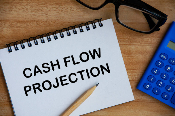 Cashflow-Projektionstext auf Notizblock mit Taschenrechner, Bleistift und Brillenhintergrund. Geschäfts- und Cashflow-Konzept - Foto, Bild