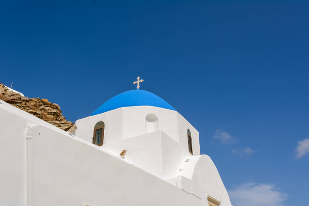 典型的なギリシャの白塗りの教会は青いドームを持つ。ギリシャキュクラデス諸島のイオス島 - 写真・画像