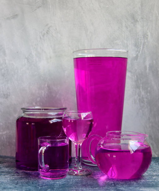 Objets en verre remplis d'eau violette et rose. Nature morte abstraite avec vaisselle en verre. Composition créative nature morte.  - Photo, image