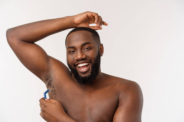 Крупным планом счастливого голого африканца, бреющегося бритвой, изолированного на сером фоне
 - Фото, изображение