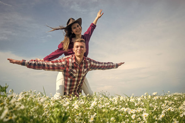 happy couple in love of man and woman in summer chamomile flower field, having fun - Photo, Image