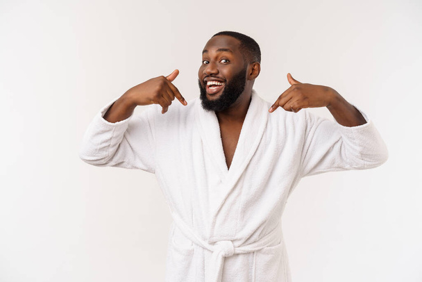 Afro-Amerikaanse man draagt een badjas met verrassing en blije emotie. Geïsoleerd over een andere achtergrond - Foto, afbeelding