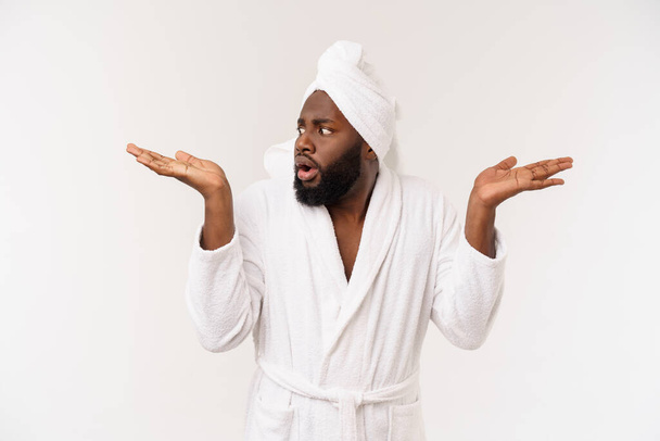 Black guy wearing a bathrobe pointing finger with surprise and happy emotion. Isolated over whtie background. - Foto, Imagem