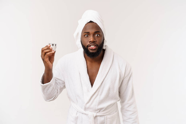 Smiling African American man applying cream on his face. Mans skin care concept - Zdjęcie, obraz