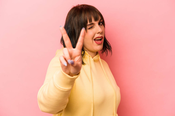 Young caucasian woman isolated on pink background showing number two with fingers. - Photo, Image