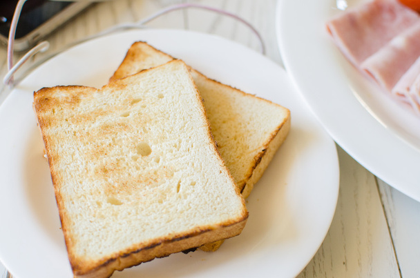 Сніданок з тостами та свинячим нарізаним шинкою
 - Фото, зображення
