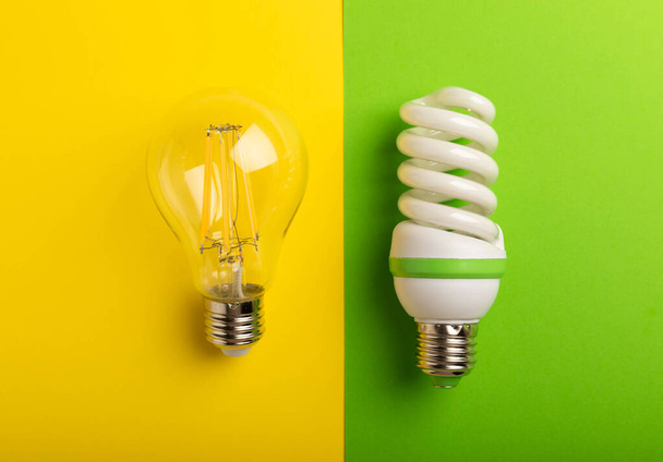 Lâmpadas eléctricas. o conceito de eficiência energética. Lâmpada LED vs lâmpada incandescente. Composição no fundo verde amarelo.Use conceito econômico e ambientalmente amigável lâmpada. - Foto, Imagem