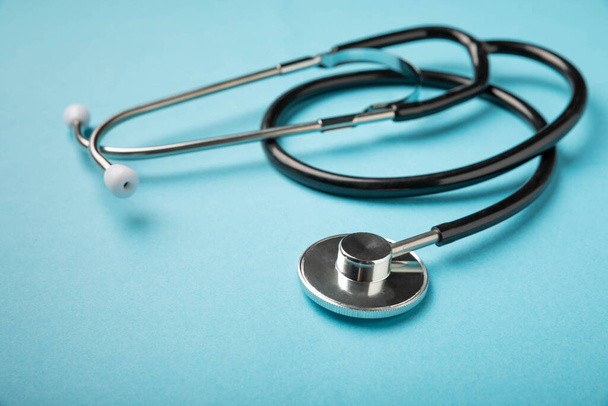 Zwarte stethoscoop op een blauwe achtergrond, closeup.Gezondheidszorg. Plaats voor tekst. Geneesmiddelenconcept - Foto, afbeelding