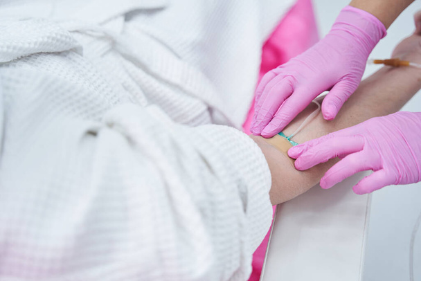 Medical worker preparing an intravenous vitamin drip treatment in beauty clinic - Fotó, kép
